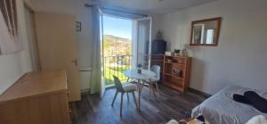 een kamer met een bed, een tafel en een raam bij Studio à 10min à pieds des Cures in Gréoux-les-Bains +2 foto's