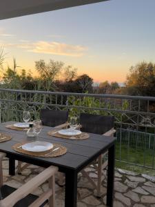 een tafel met wijnglazen en stoelen op een patio bij Artemis Villa in Fiskardho