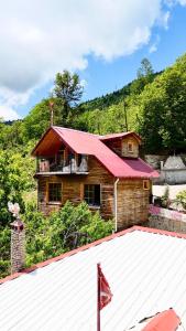 a wooden house with a red roof and a building at Isgobya Sumela Monastery 106 in Macka