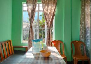 a table with a vase on it in a room with a window at Vila's Homestay in Kohīma