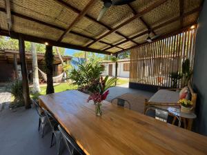 een houten tafel en stoelen op een terras bij Pousada Nalu - Camburi in São Sebastião