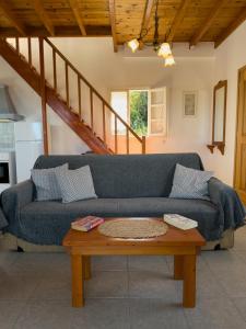 een woonkamer met een blauwe bank en een tafel bij Artemis Villa in Fiskardho