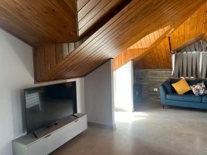 een woonkamer met een bank en een grote flatscreen-tv bij Terminal K Bhamdoun Hotel in Aley