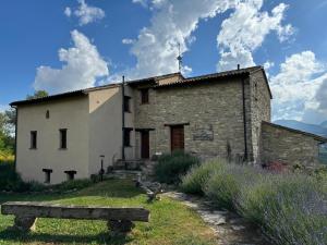 an old stone building with a bench in front of it at Casale le Fontanelle in Monte Grimano Terme