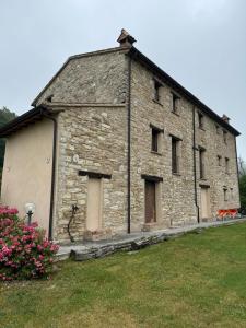 an old stone building with windows and a yard at Casale le Fontanelle in Monte Grimano Terme +13 photos