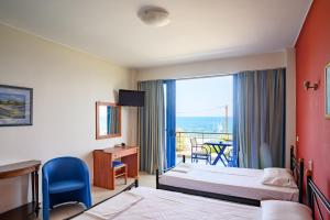 a hotel room with two beds and a balcony at Hotel Dimitra in Tsoukalaíika