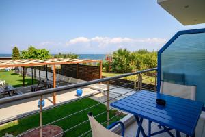 a blue table on a balcony with a view of the ocean at Hotel Dimitra in Tsoukalaíika