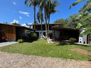 a house with palm trees in front of it at Pousada Nalu - Camburi in Camburi