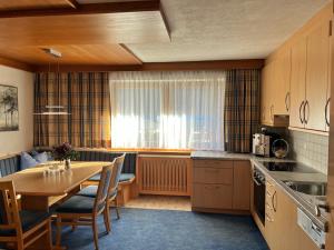 a kitchen with a table and a dining room at Appart Leni in Pfunds +3 photos