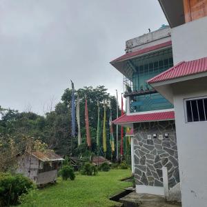 a building with flags on the side of it at Vajrayogini Inn in Pedong