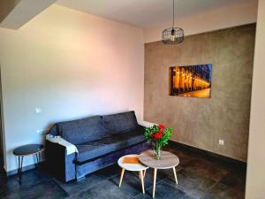 a living room with a blue couch and a table at Andreas' Guest House in Káto Spílaion