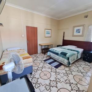 een slaapkamer met een bed en een ventilator. bij HostHub Guest House in Rustenburg