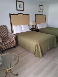 ein Hotelzimmer mit einem Bett und einem Stuhl in der Unterkunft Stay Express Inn & Suites Demopolis in Demopolis