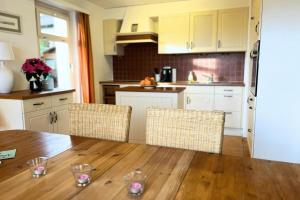 a kitchen with a wooden table and two chairs at Charming house with mountain view in Hämikon