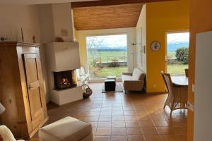 a living room with a fireplace and a table and chairs at Charming house with mountain view in Hämikon