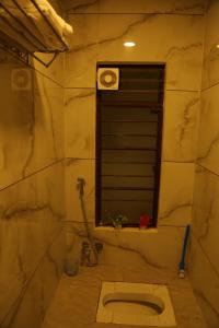 een badkamer met een toilet en een raam bij ShivAOM Family Homestay in Ujjain +34 foto's