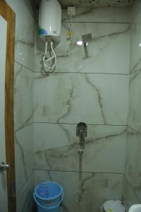 een badkamer met een marmeren douche met kraan bij ShivAOM Family Homestay in Ujjain +31 foto's