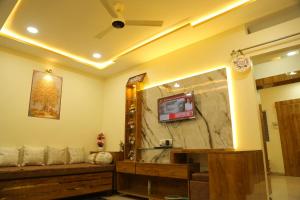 een badkamer met een grote spiegel en een tv aan de muur bij ShivAOM Family Homestay in Ujjain