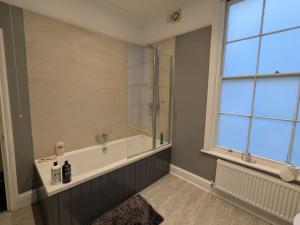 ein Badezimmer mit Dusche und Badewanne in der Unterkunft Seaside 3 bed terraced house in Hastings