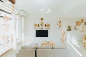 a white living room with a couch and a tv at Casa con alberca privada 3BR Ideal para familias y grupos Hasta 9 personas in Cancún