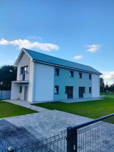 a large white building with a fence in front of it at Czapury in Czapury