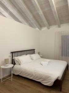 una camera da letto con un grande letto bianco e un soffitto in legno di Tarsilla Appartamenti - Centro Storico a Caorle Altre 27 foto