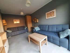 een woonkamer met een blauwe bank en een tafel bij Czapury in Czapury