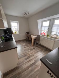 eine Küche mit Tisch und Stühlen in einem Zimmer in der Unterkunft Ferienwohnung Unger in Großhartmannsdorf