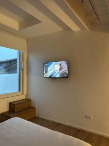 una camera da letto con un letto e una televisione a parete di Tarsilla Appartamenti - Centro Storico a Caorle
