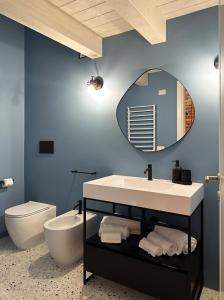 un bagno con lavandino, WC e specchio di Tarsilla Appartamenti - Centro Storico a Caorle