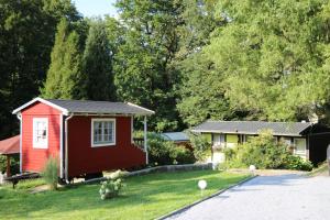 a small red house in a yard next to a house at Annis- Romantikhäuschen in Königstein an der Elbe