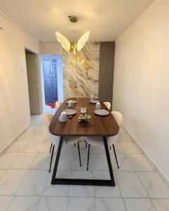 a dining room with a wooden table and chairs at Kuala Terla Cameron Cozy Home - Self Check-in in Kampung Kuala Terla +6 photos