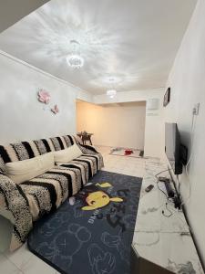 a living room with a couch and a tv at Kuala Terla Cameron Cozy Home - Self Check-in in Kampung Kuala Terla