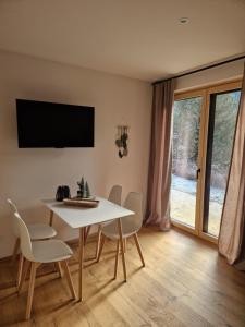 a dining room with a white table and chairs at Haus Robi Wood in Bad Kleinkirchheim