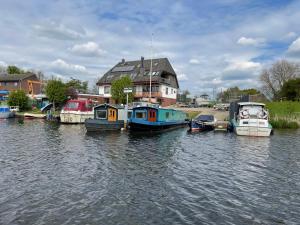 a group of boats are docked in a river at Hausboot Lütje in Hamburg