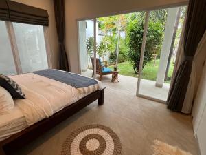ein Schlafzimmer mit einem Bett und einer Glasschiebetür in der Unterkunft Villa Serenity Beachfront Bali in Pengastulan + 51 Fotos