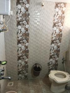 a bathroom with a toilet and a rock wall at Keshav in Bhuj