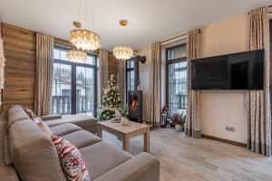 ein Wohnzimmer mit einem Sofa, einem TV und einem Weihnachtsbaum in der Unterkunft Finlandia Chalet in Bukowel