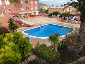 - une piscine dans une cour avec des arbres et des bâtiments dans l'établissement Mar y Sol I Candelaria, à Punta Larga