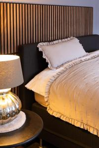 a bedroom with a bed and a table with a lamp at Het Woonrijk in Bennekom