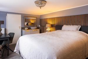 a bedroom with a large white bed and a desk at Het Woonrijk in Bennekom