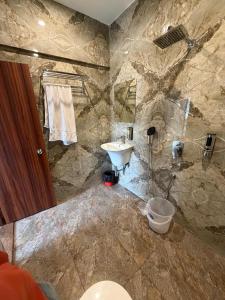 een stenen badkamer met wastafel en toilet bij Hr Palace in Varanasi +12 foto's