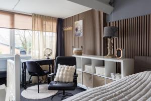 Bennekom居住区住宿加早餐旅馆的一间卧室，配有一张床、一张桌子和一把椅子