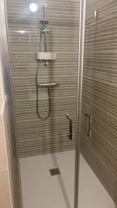 une douche avec une porte en verre dans une salle de bain dans l'établissement Home far from home, à Castelnuovo del Garda