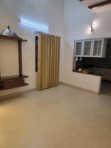a living room with a television and a window at Ixe Stays in Mangalore