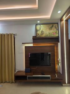 a living room with a flat screen tv at Ixe Stays in Mangalore
