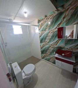 a bathroom with a white toilet and a sink at Mini Casa Mezanino in São Francisco do Sul