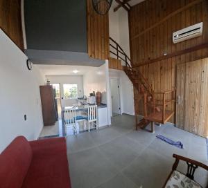 a living room with a staircase and a kitchen at Mini Casa Mezanino in São Francisco do Sul