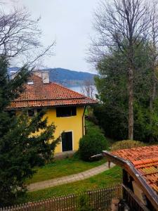 ein gelbes Haus mit einem Zaun davor in der Unterkunft Ferienwohnung "Hochfeld Seeblick" in Tegernsee