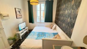 una piccola stanza con un letto e una televisione di Studio cosy - Quartier Prébendes, Tours centre a Tours